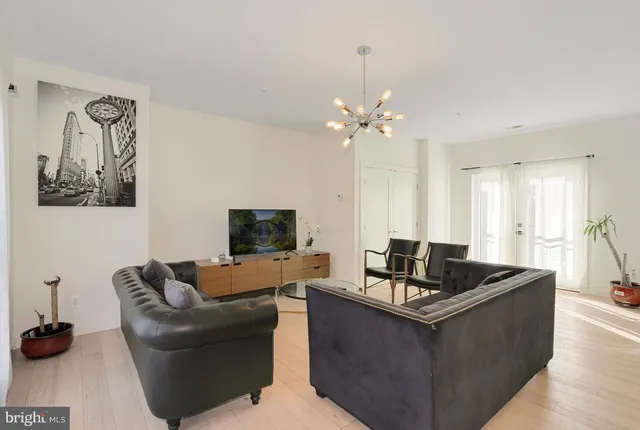a living room with furniture kitchen and a chandelier