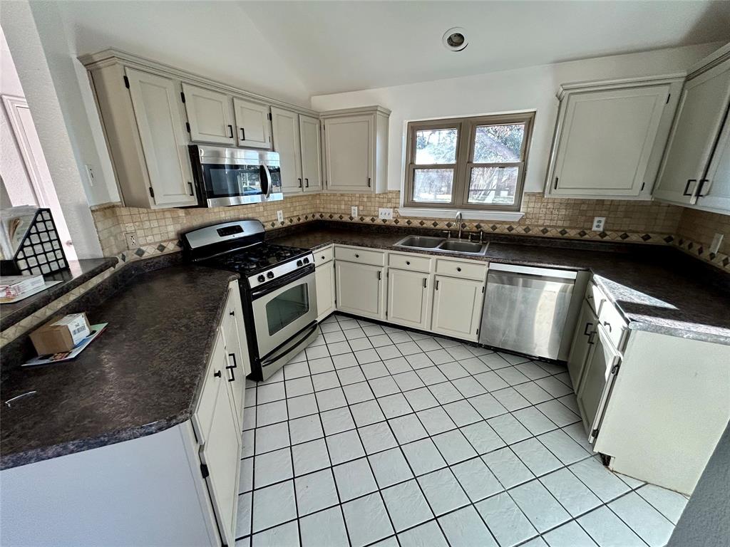 2218 Fuqua Road Rowlett, TX 75088 - Photo 3 of 14 a kitchen with a sink appliances and cabinets