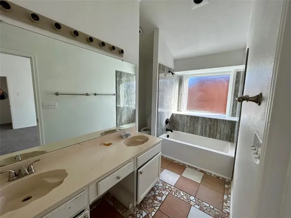 a bathroom with a sink a tub and a mirror