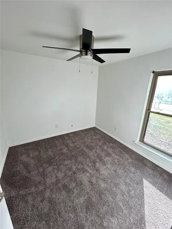 a view of a room with a window and a ceiling fan