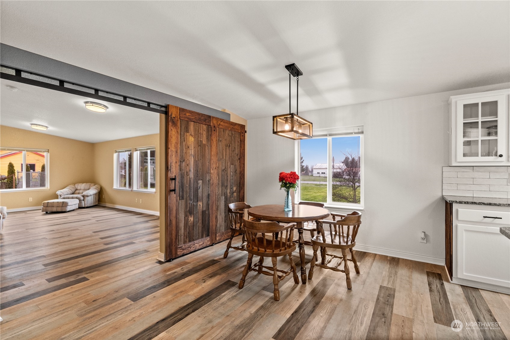 901 West Hendrickson Road Sequim, WA 98382 - Photo 11 of 39 a view of a dining room and livingroom with furniture wooden floor a chandelier