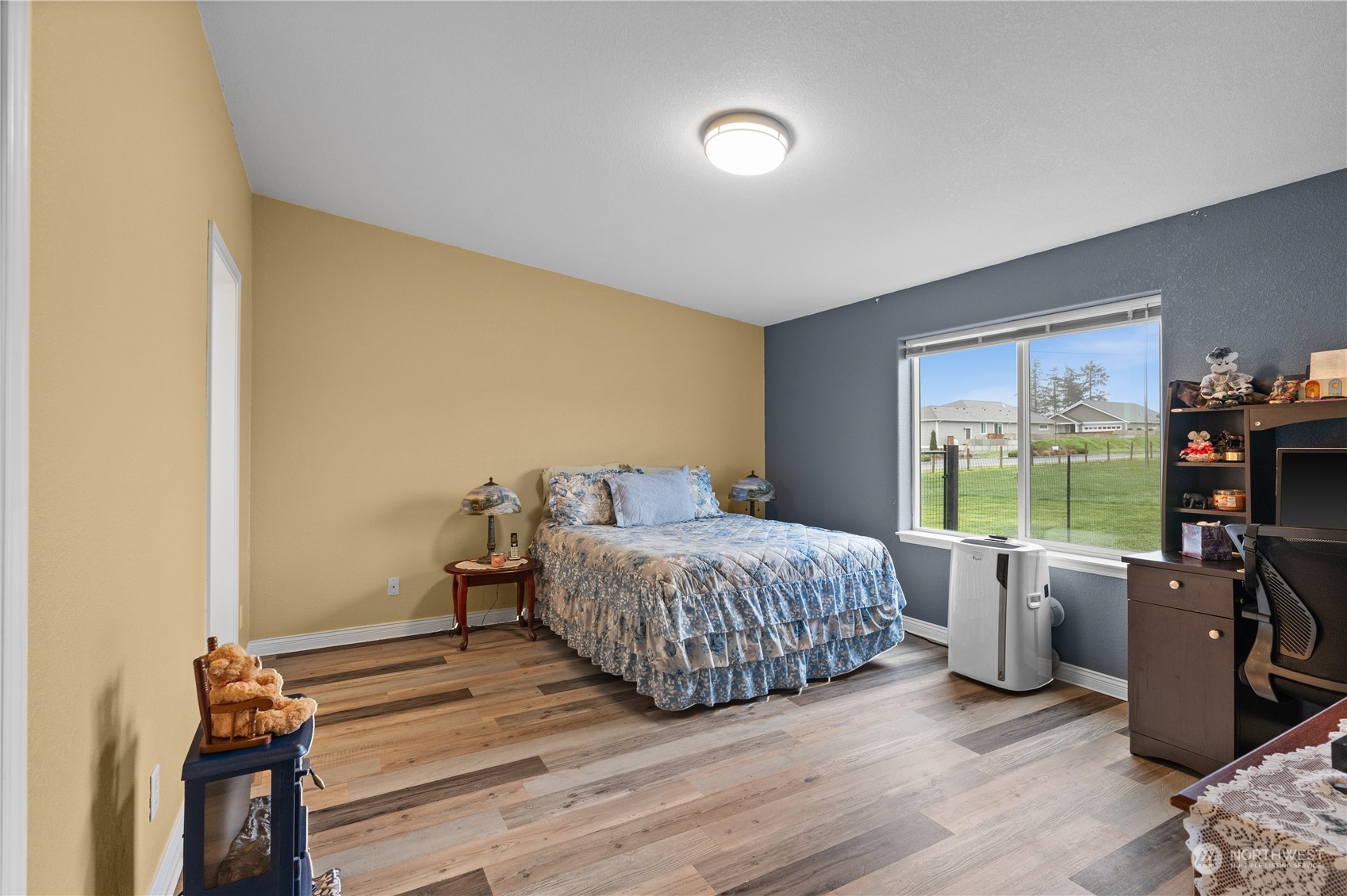 901 West Hendrickson Road Sequim, WA 98382 - Photo 23 of 39 a bedroom with a bed and wooden floor