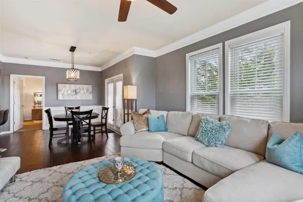 a living room with furniture kitchen view and a window