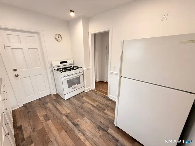 a kitchen with a refrigerator a stove and white cabinets