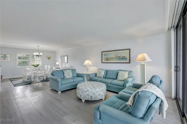a living room with furniture a flat screen tv and a floor to ceiling window
