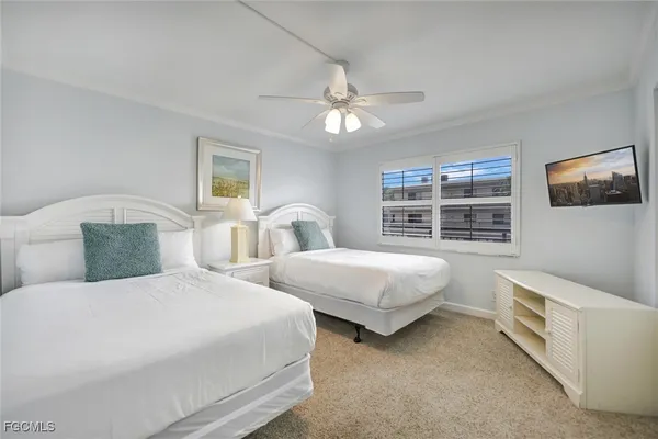 a bedroom with two beds and painting on the wall
