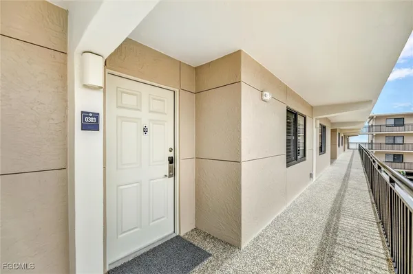a hallway with white cabinets and white appliances