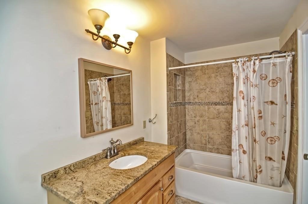 41 Webber Street, Unit 1 Malden, MA 02148 - Photo 11 of 22 a bathroom with a granite countertop sink mirror and a bathtub