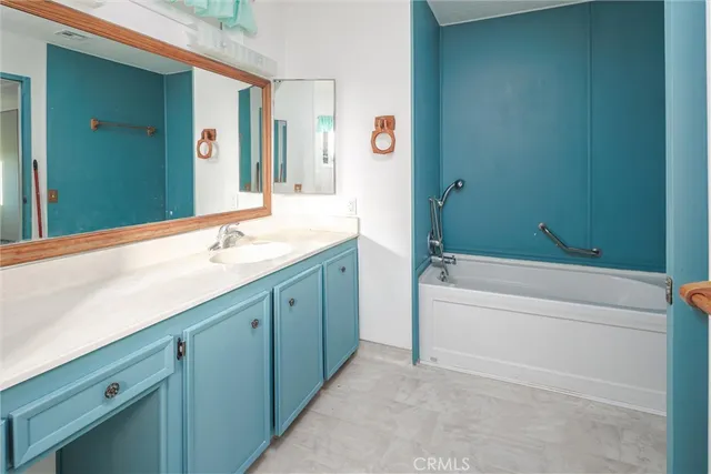a bathroom with a tub sink and mirror