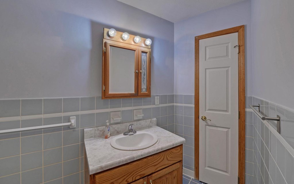 1720 Caney Creek Road Murphy, NC 28906 - Photo 12 of 69 a bathroom with a granite countertop sink a mirror and a vanity