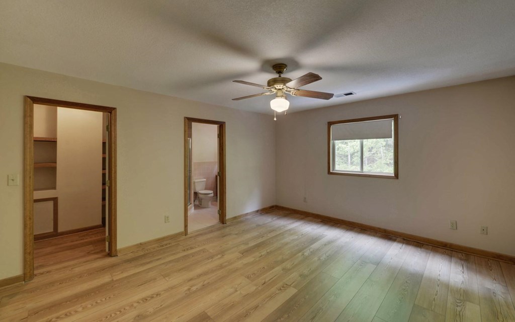 1720 Caney Creek Road Murphy, NC 28906 - Photo 7 of 69 an empty room with wooden floor chandelier fan and windows