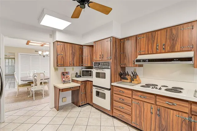 a kitchen with a stove cabinets and chairs
