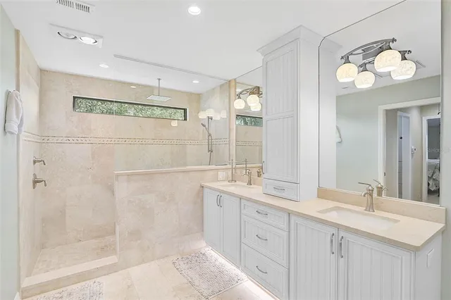 a bathroom with a double vanity sink mirror and a shower
