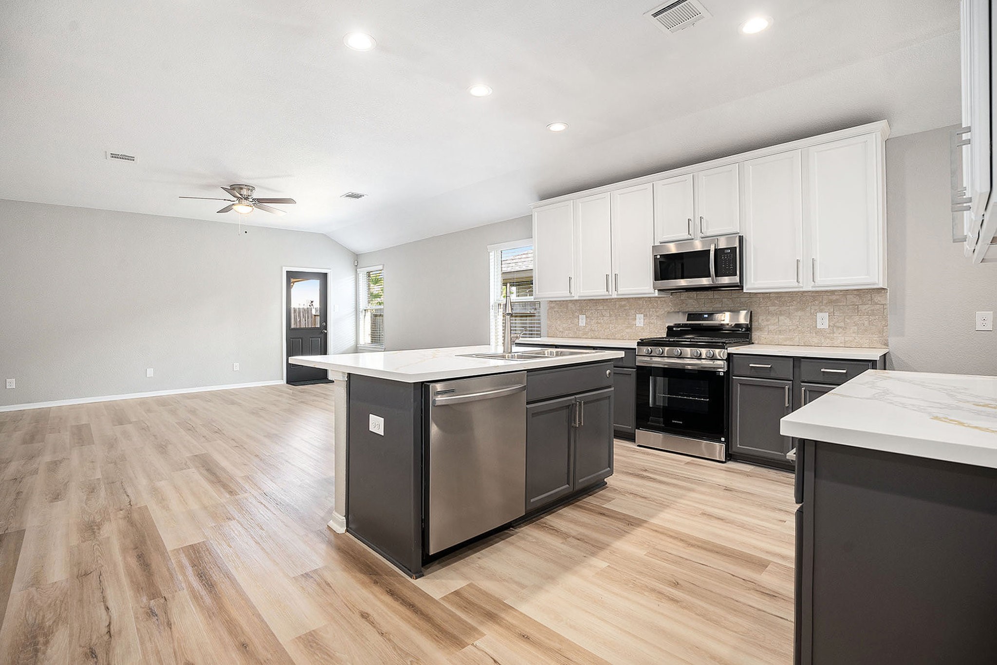4027 Spurwing Lane Baytown, TX 77521 - Photo 12 of 34 This photo showcases a spacious, open-concept kitchen and living area with modern appliances, a large island, and sleek cabinetry. All appliances are brand new!