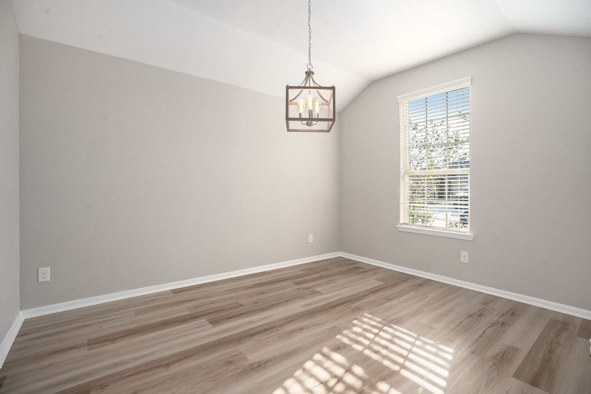 4027 Spurwing Lane Baytown, TX 77521 - Photo 15 of 34 This room features a high ceiling with a modern light fixture and large window with blinds allowing natural light. Ideal for a cozy living or dining space. It could also be used as home office.
