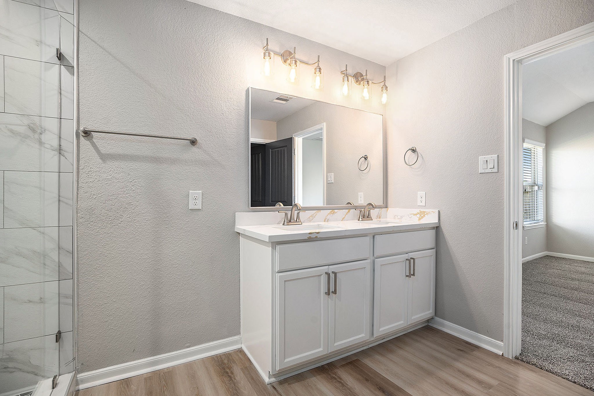 4027 Spurwing Lane Baytown, TX 77521 - Photo 24 of 34 Modern bathroom with a double vanity, large mirror, and stylish lighting. There is also a water closet.