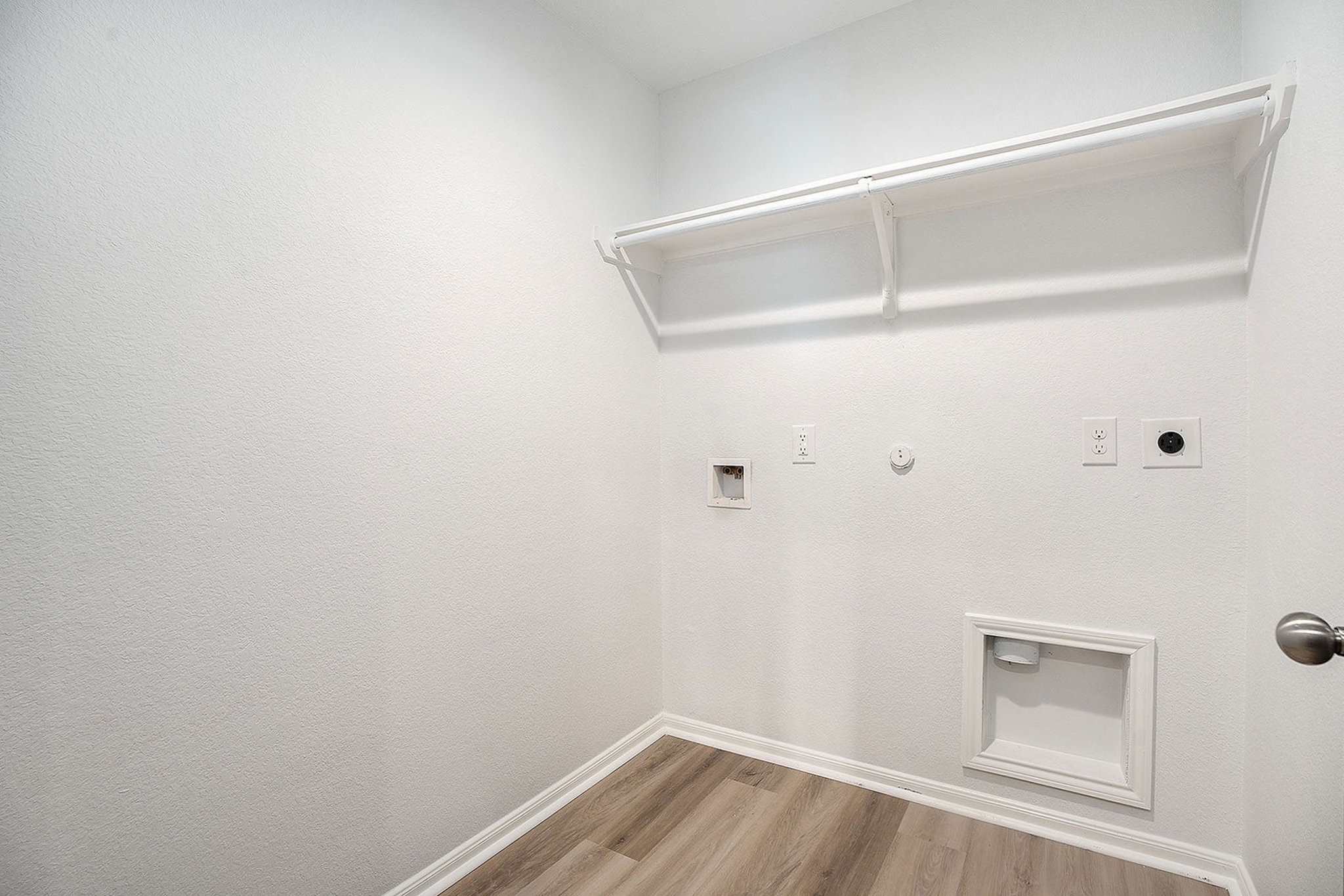 4027 Spurwing Lane Baytown, TX 77521 - Photo 27 of 34 This is a spacious laundry room with hookups for a washer and dryer. A shelf above provides additional storage space.