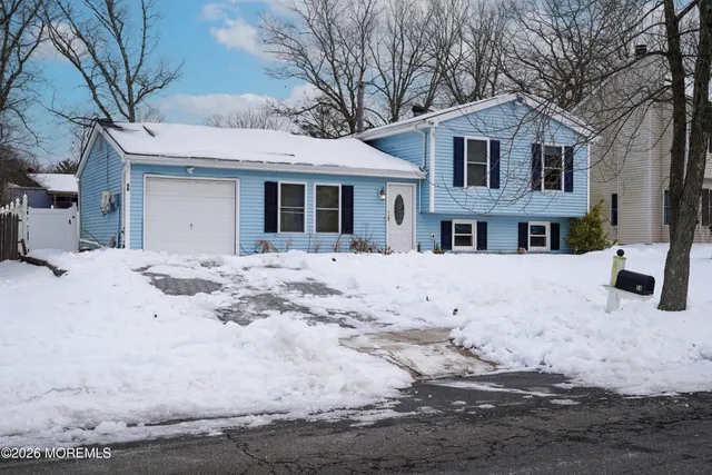 a front view of a house with a yard covered in snow
