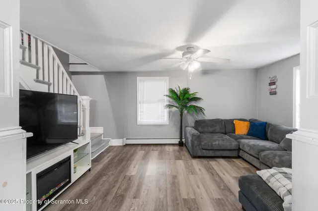 a living room with furniture and a wooden floor