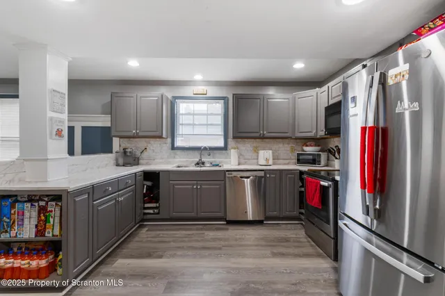a large kitchen with stainless steel appliances granite countertop a refrigerator and a stove