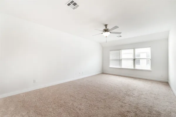 an empty room with windows and chandelier fan