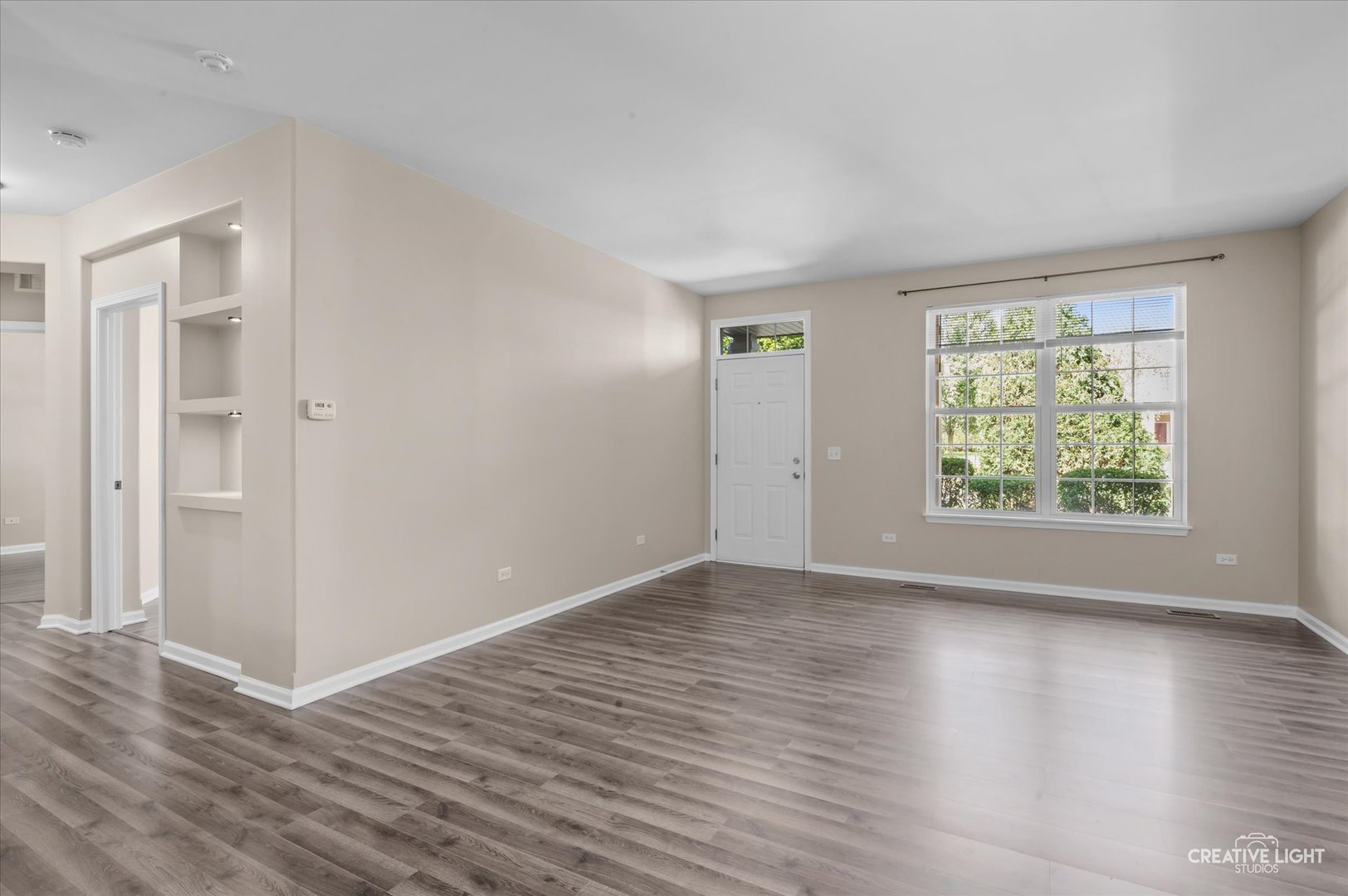 8814 Concord Lane, Unit H Justice, IL 60458 - Photo 3 of 17 an empty room with wooden floor and windows