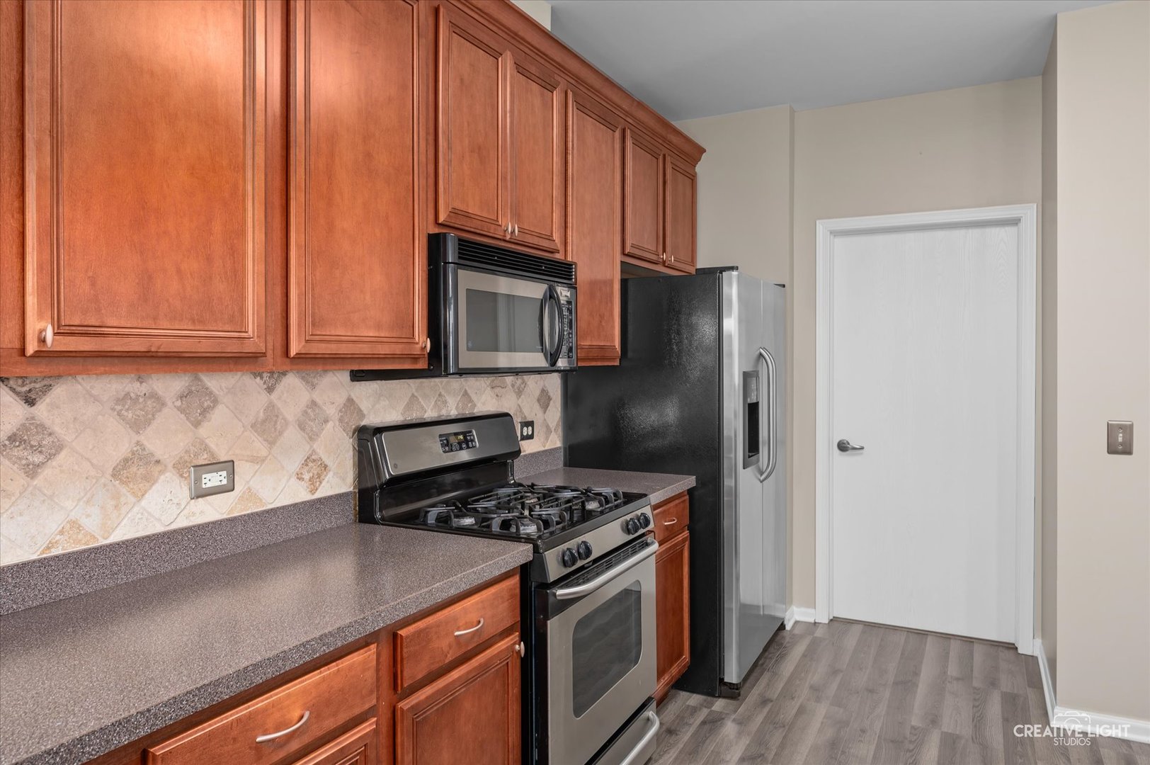8814 Concord Lane, Unit H Justice, IL 60458 - Photo 5 of 17 a kitchen with stainless steel appliances granite countertop a refrigerator stove and cabinets