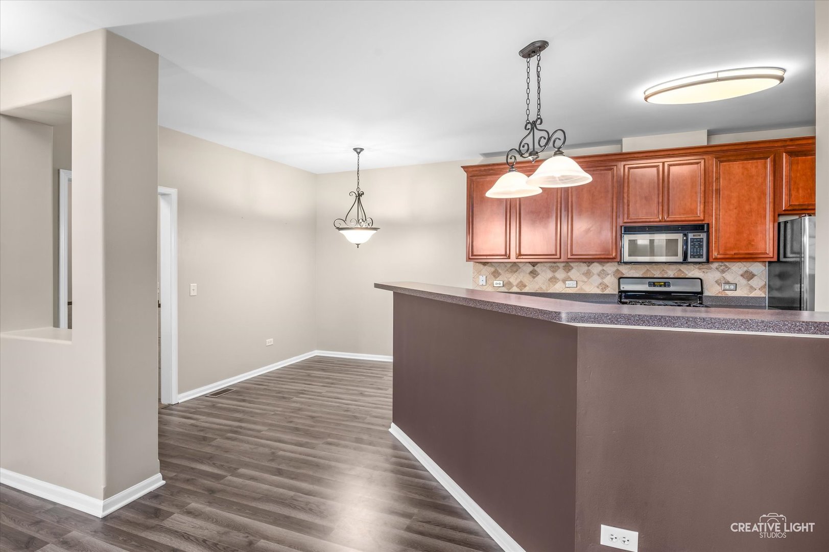 8814 Concord Lane, Unit H Justice, IL 60458 - Photo 7 of 17 a kitchen with stainless steel appliances granite countertop a sink a stove and a wooden floors