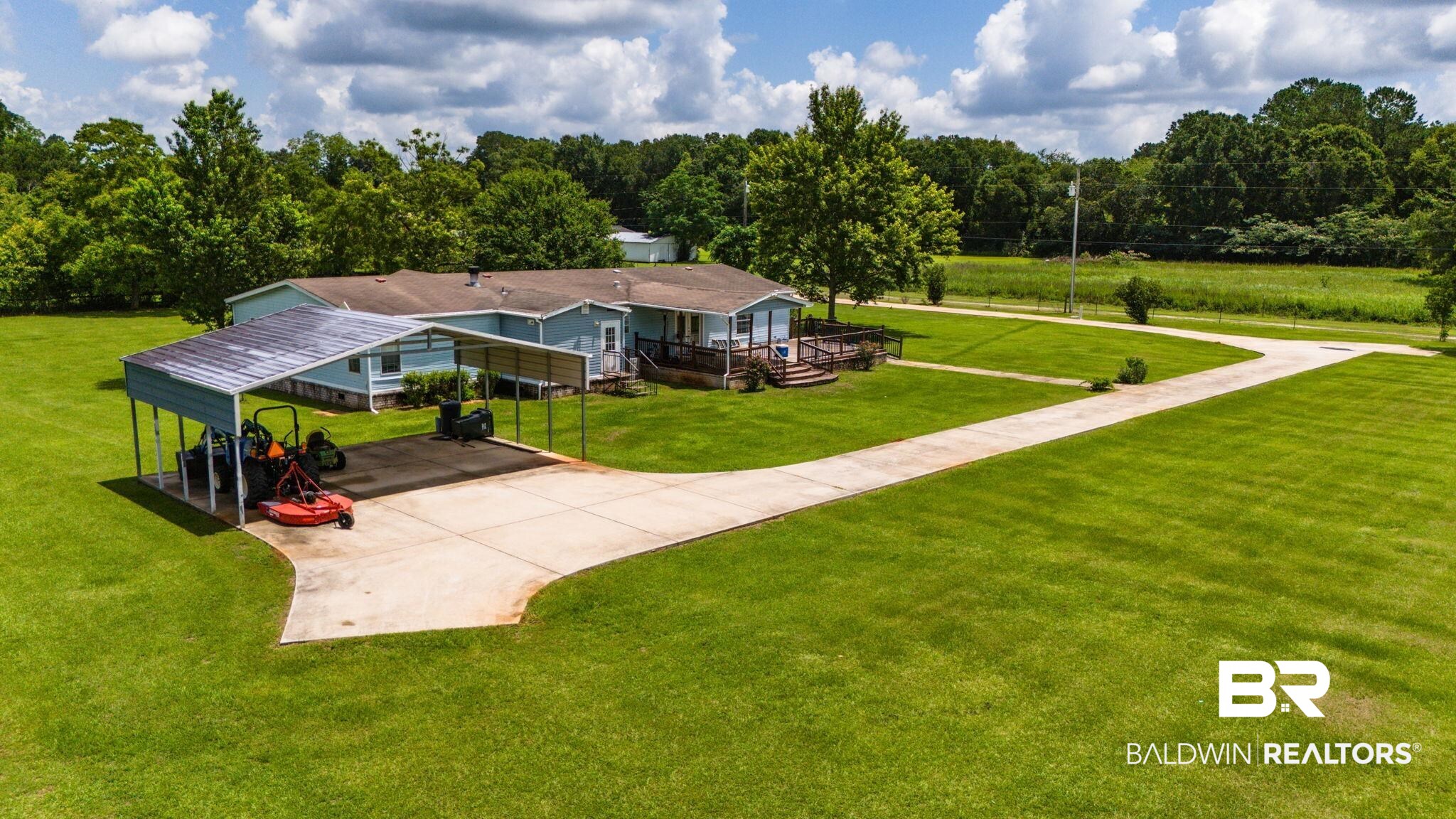 34985b Spring Road South, Unit B Stapleton, AL 36578 - Photo 30 of 31 Expansive green lawn with a long concrete driveway, leading to a blue exterior residence with a covered carport