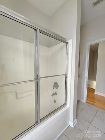 a bathroom with a glass shower door