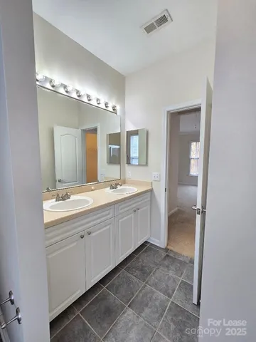 a large bathroom with a double vanity sink and a mirror