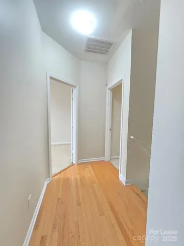 a view of a big room with wooden floor and a bathroom