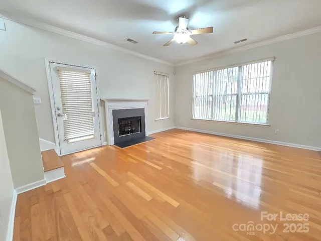 a view of an empty room with a fireplace and a window