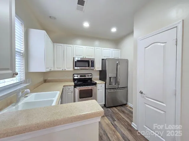 a kitchen with a refrigerator and a sink