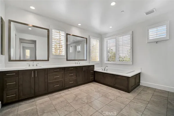 a spacious bathroom with double vanity and a mirror