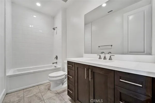 a bathroom with a sink a toilet and a large mirror