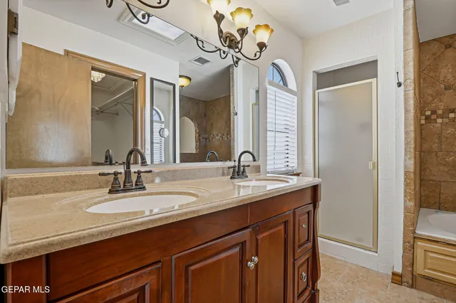 an empty room with a chandelier fan and windows