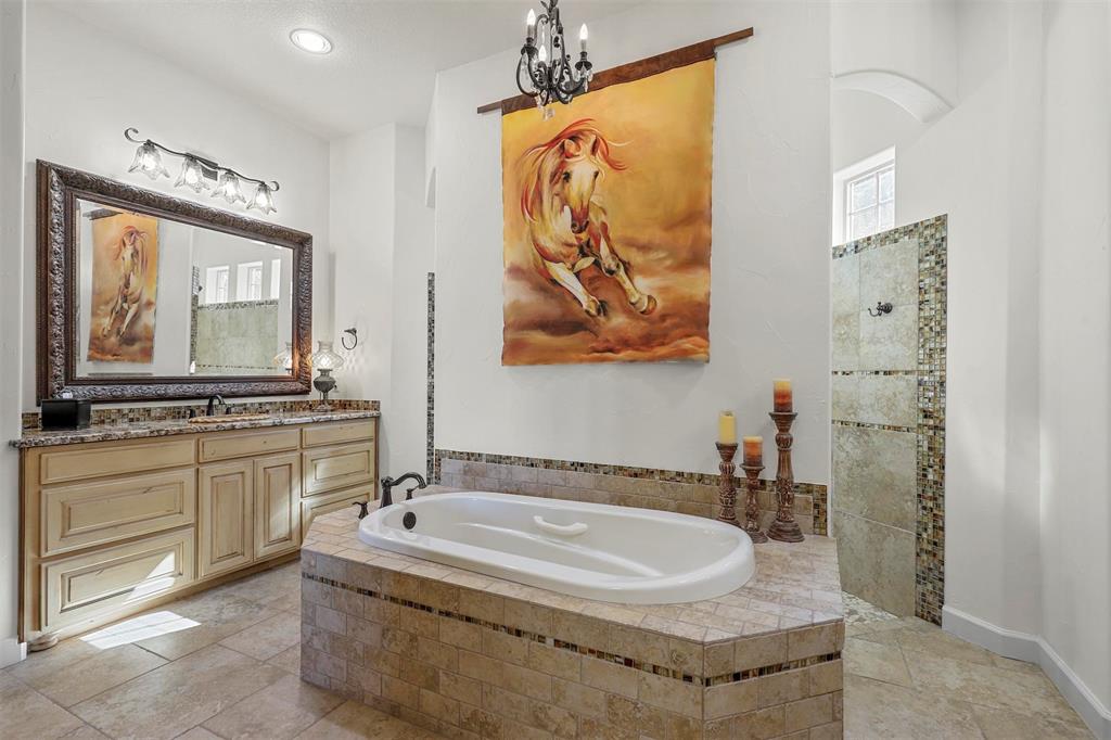 701 Cactus Rio Weatherford, TX 76087 - Photo 22 of 40 a bathroom with a tub a sink and mirror
