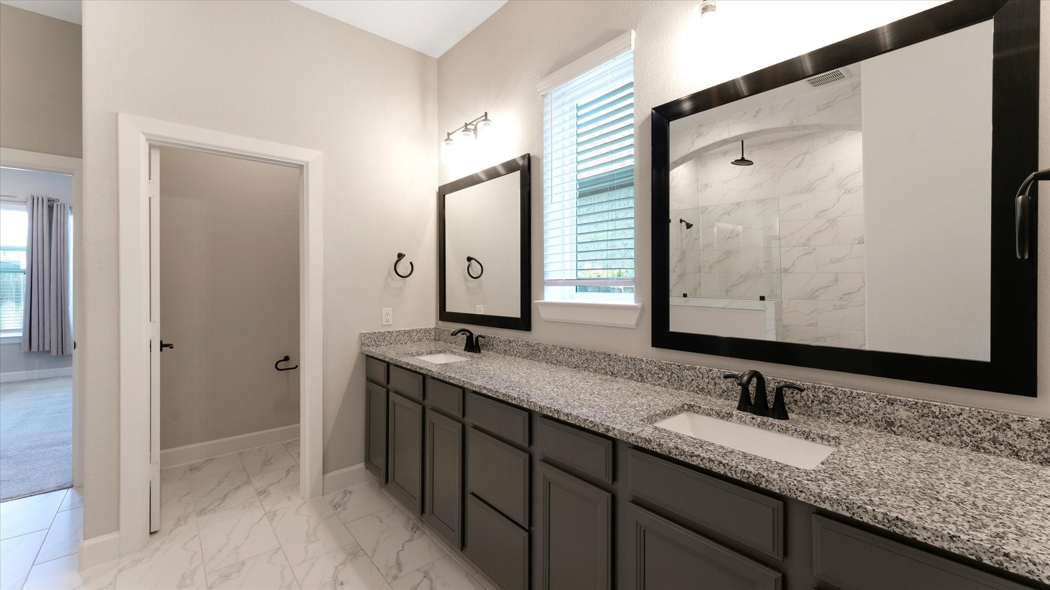 15607 Rising Wren Court Conroe, TX 77302 - Photo 22 of 40 a bathroom with a granite countertop double vanity sink and mirror