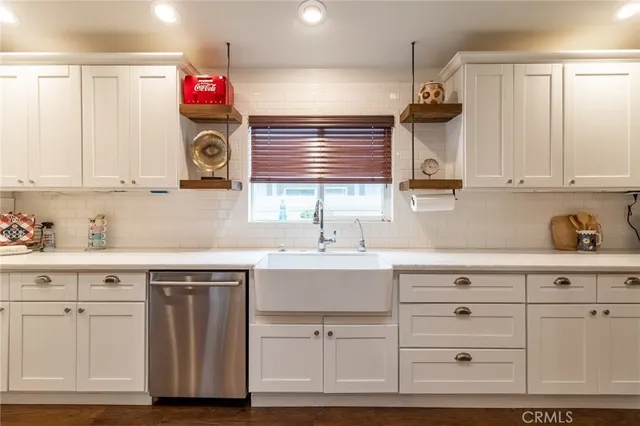 a kitchen with white cabinets and sink