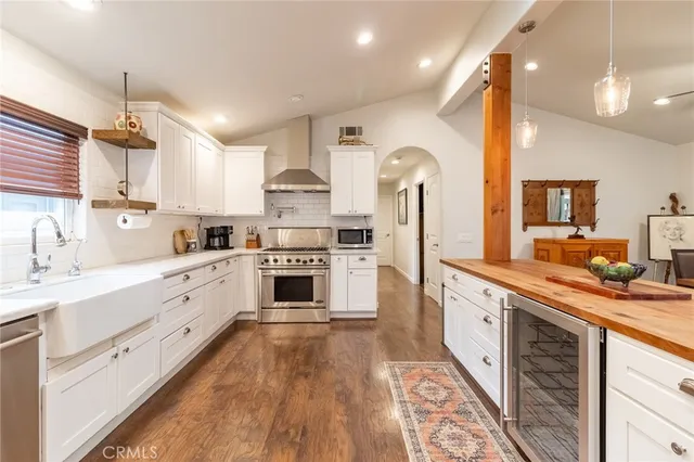 a kitchen with white cabinets appliances and a sink