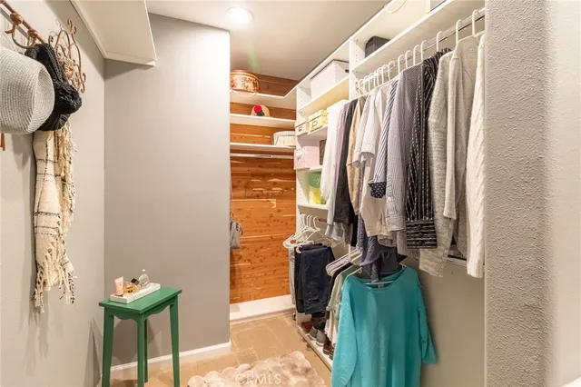 a view of walk in closet with clothes and shoes