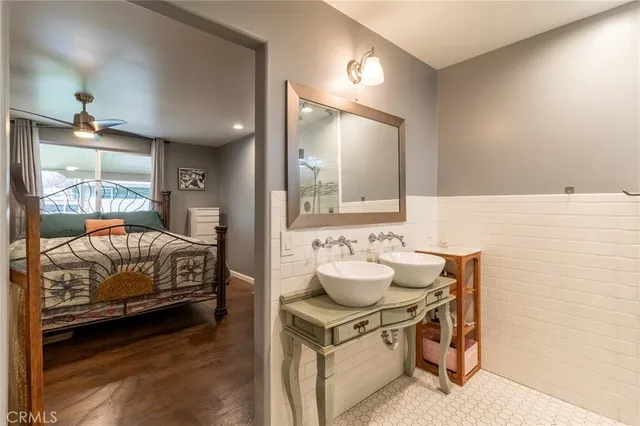 a en suite bathroom with a double vanity sink and a mirror