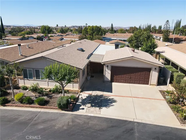 an aerial view of a house with a yard and parking