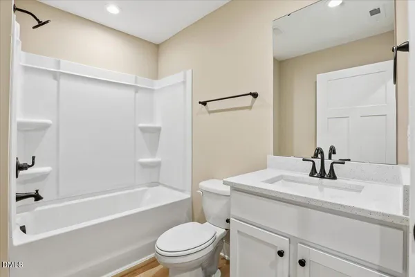 a white toilet sitting next to a bath tub