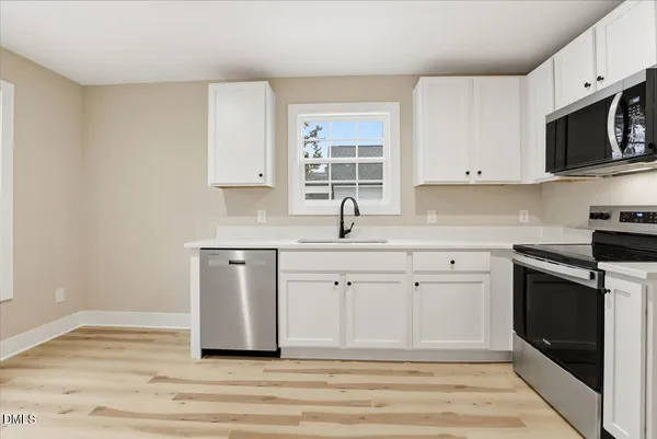 a kitchen with a sink cabinets and window