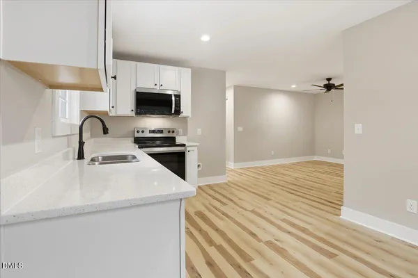 a kitchen with stainless steel appliances white cabinets and a sink