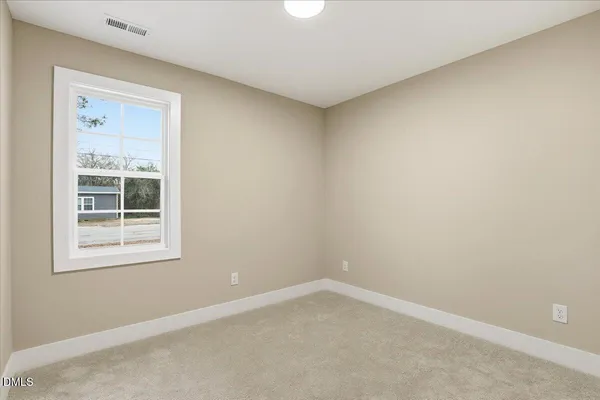 an empty room with wooden floor a ceiling fan and windows