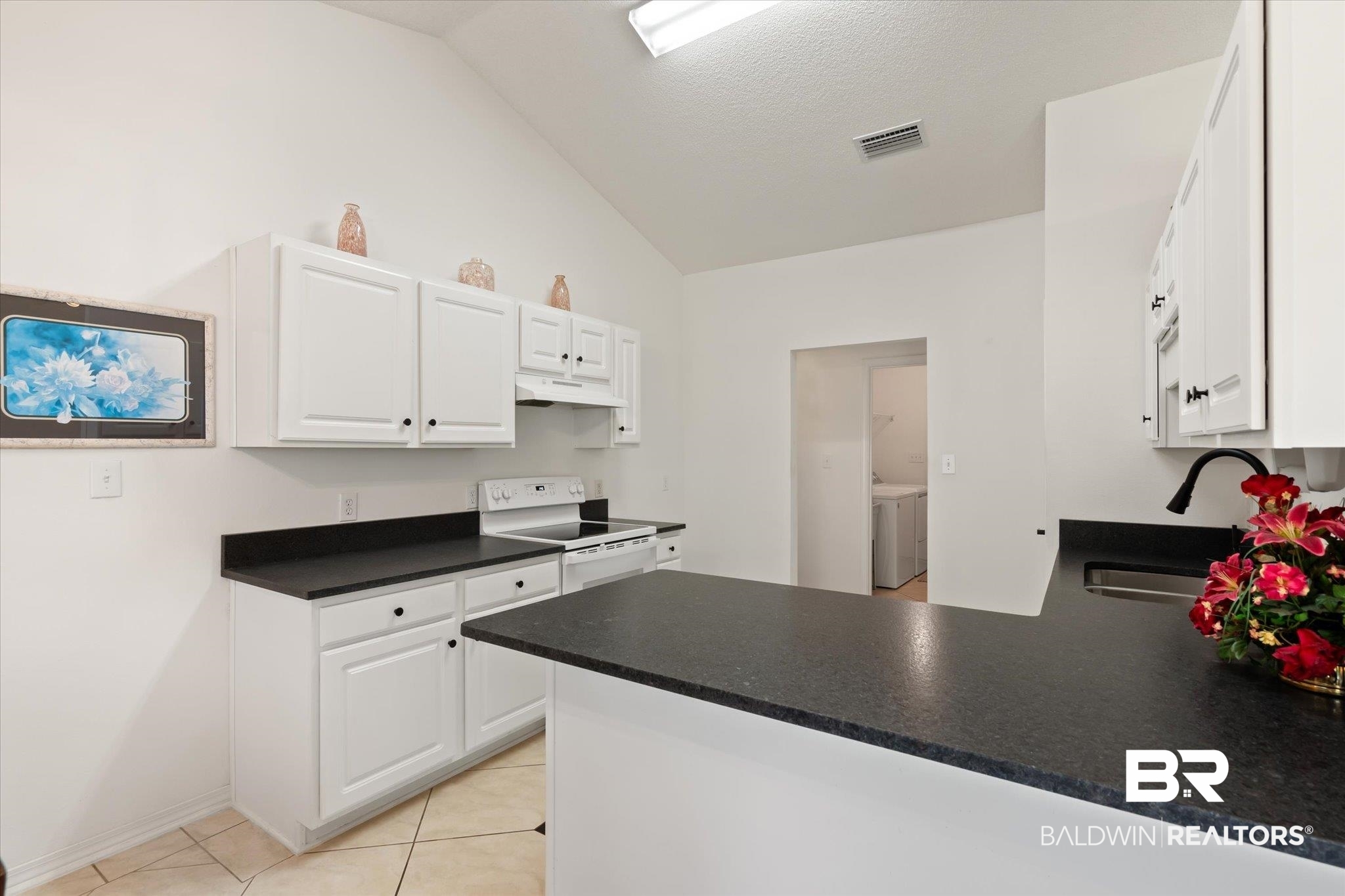 12520 Hunters Chase Foley, AL 36535 - Photo 19 of 32 Kitchen featuring under cabinet range hood, washing machine and dryer, a peninsula, white electric range oven, and a sink