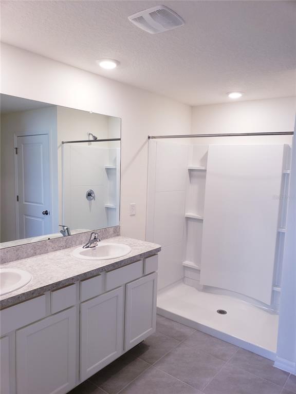 12211 Kingsley Trail Parrish, FL 34219 - Photo 21 of 28 a bathroom with a granite countertop sink a mirror a shower and a mirror